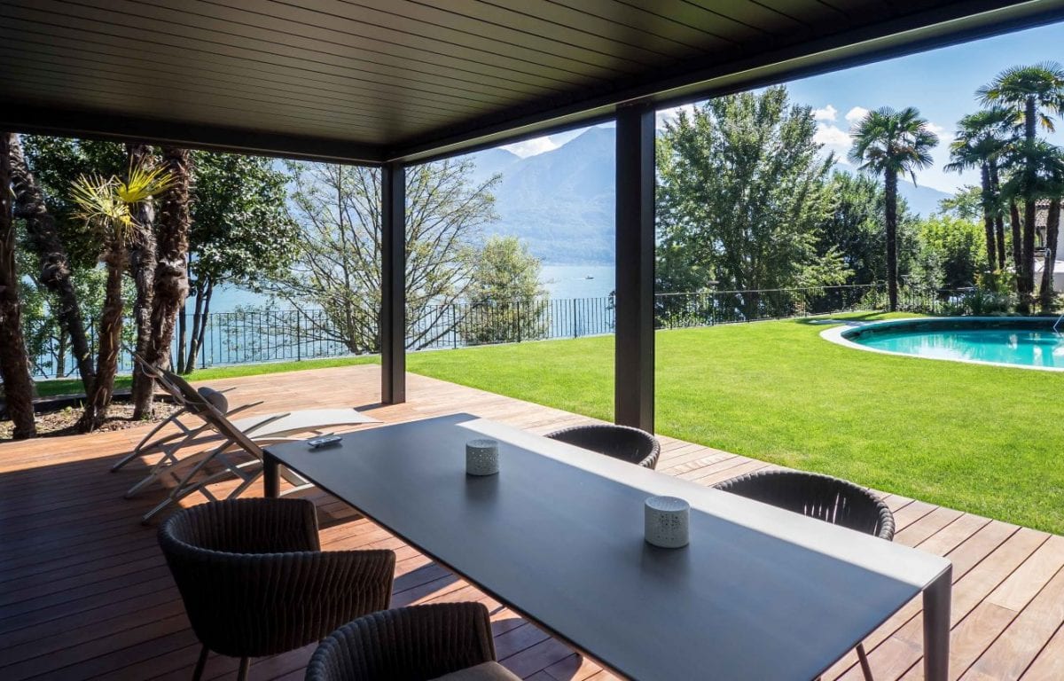 La pergola bioclimatica Opera permette di realizzare un living privato e riparato che affaccia sul Lago di Locarno in Svizzera