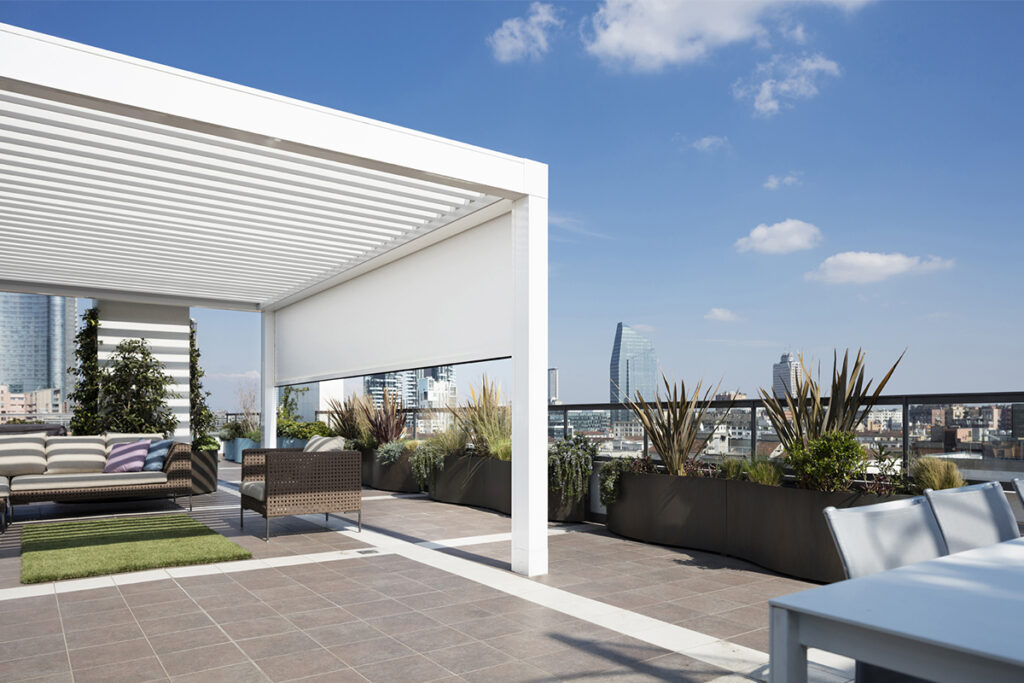 Pergola Opera per terrazzo con tende verticali Raso, skyline Milano