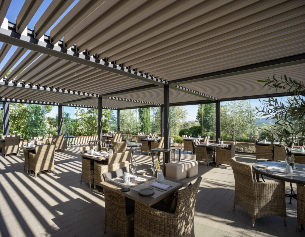 Opera bioclimatic pergola with panoramic glass windows in a Tuscan dehors
